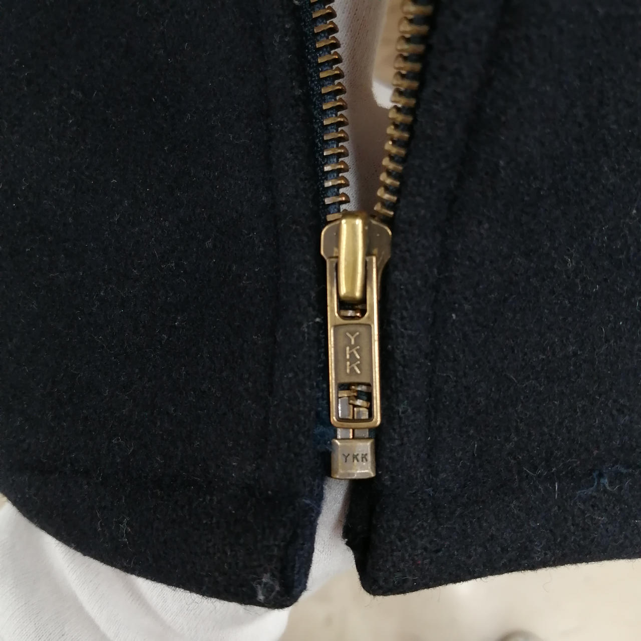 ファスナー留め具付近の布裂けてます。