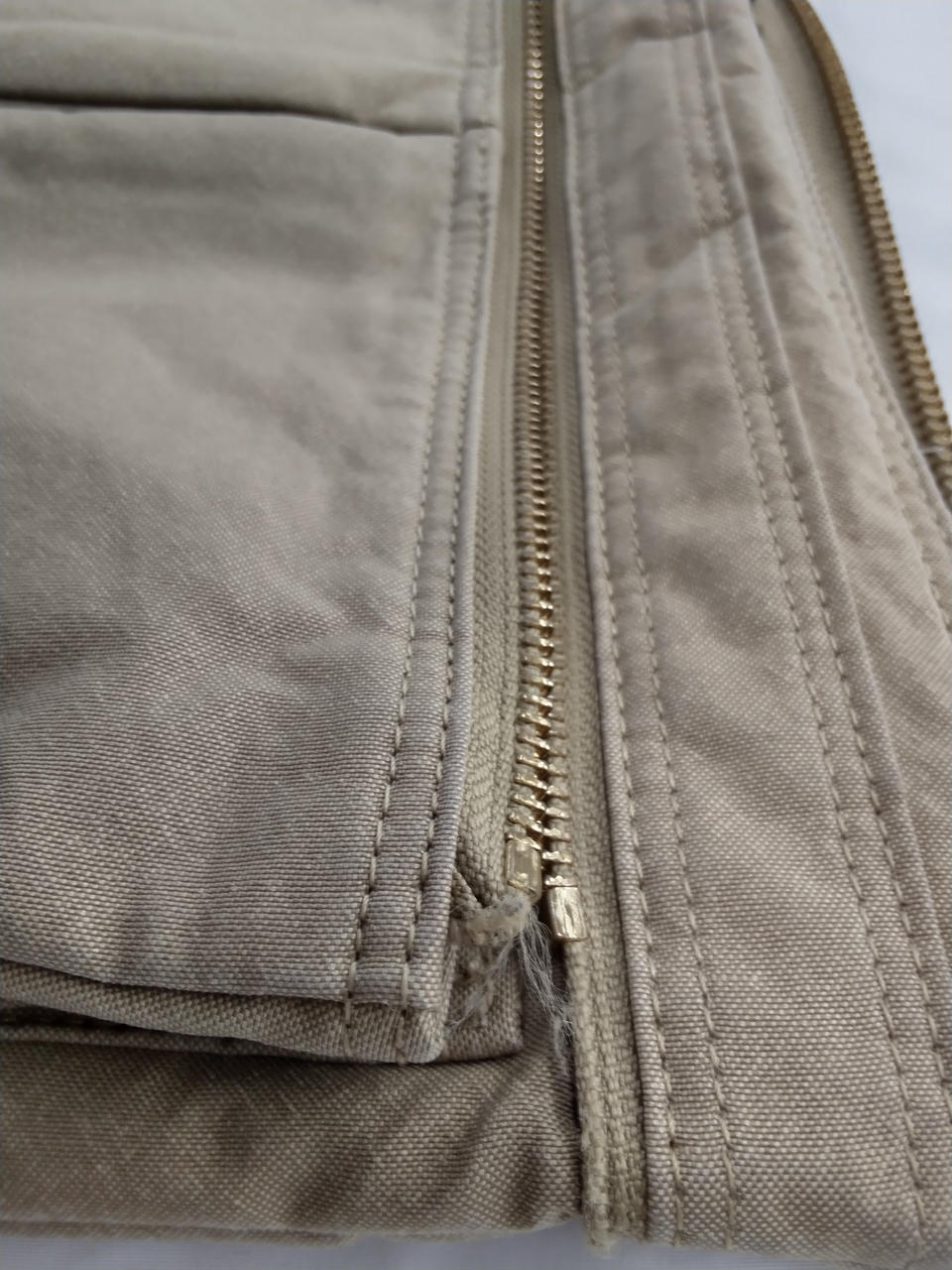 ファスナーの端に糸が出ています。