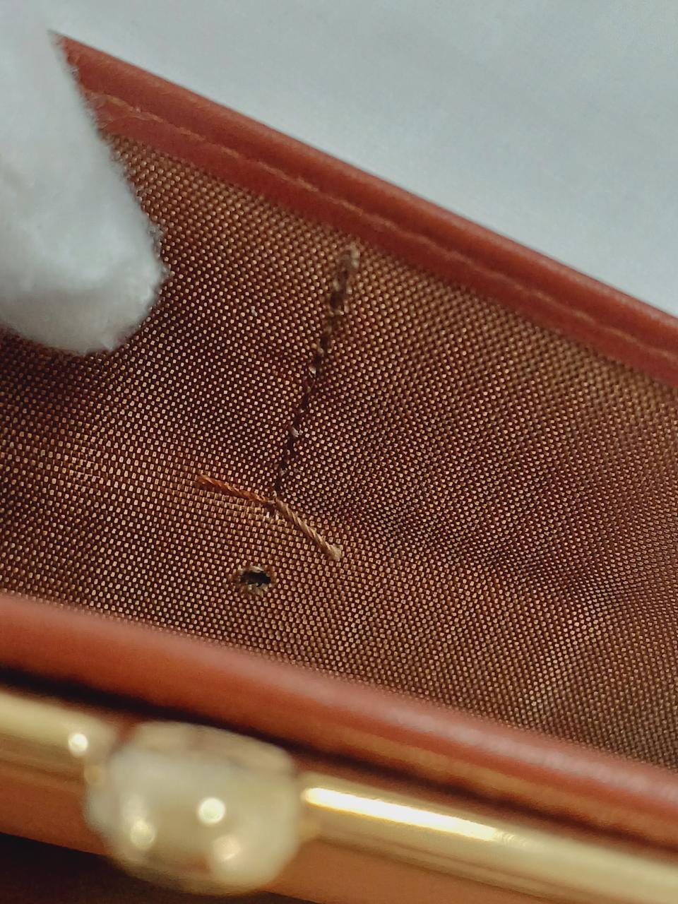 生地に穴開きがある部分、金具の欠品です
